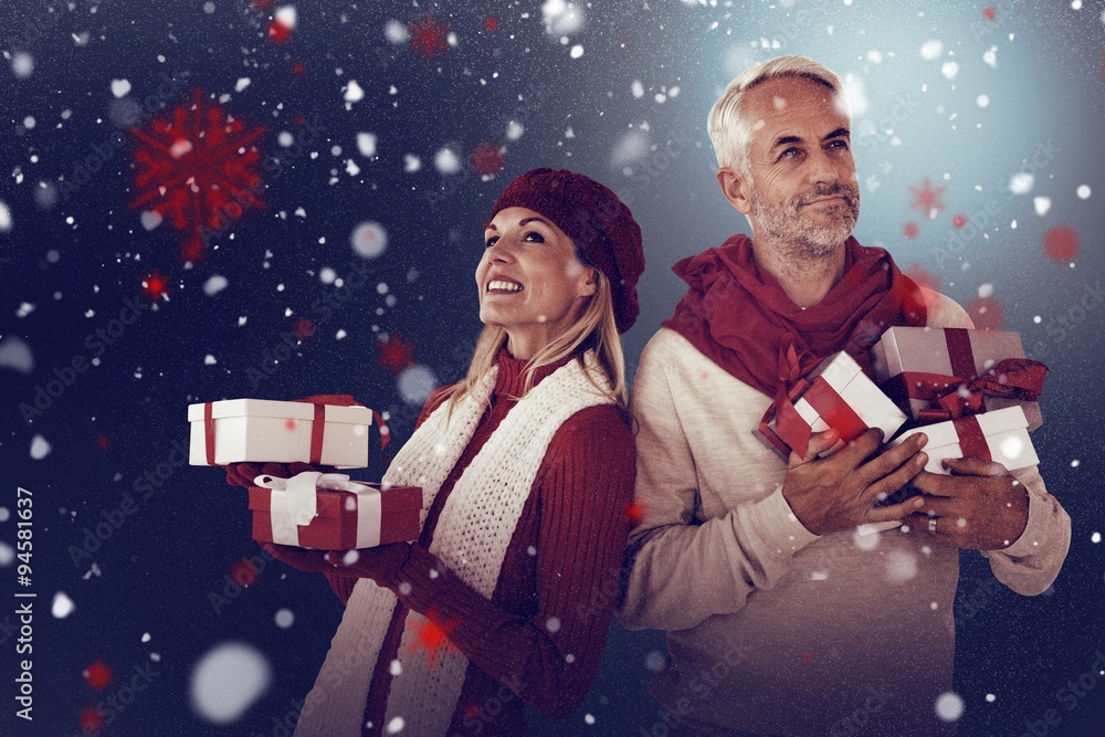 Composite image of happy festive couple with gifts