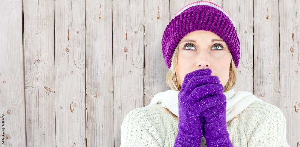 Composite image of young woman wearing gloves looking up