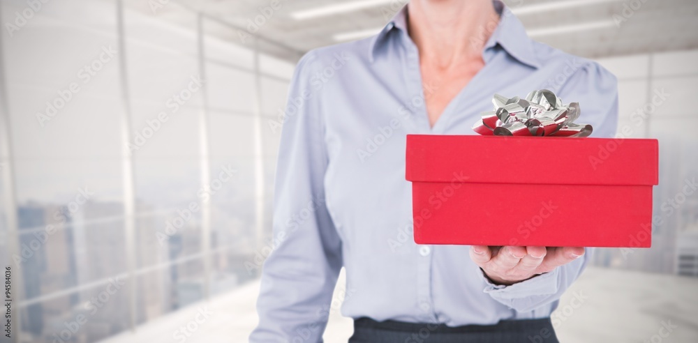 Composite image of businesswoman holding digital tablet