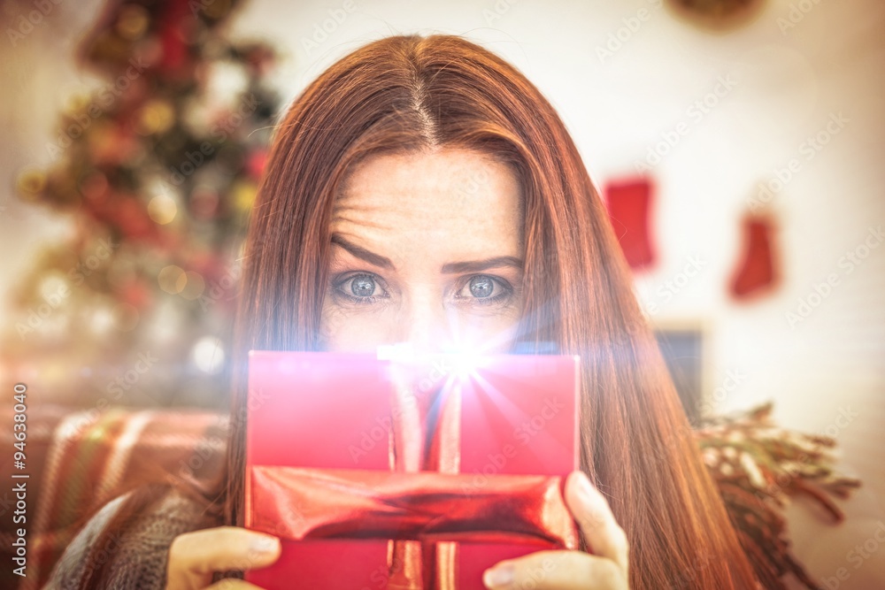 Festive redhead with gift on the couch