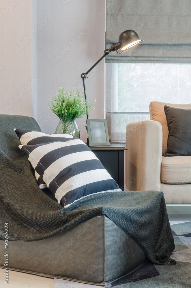 black and white pillows on black sofa with modern lamp on table