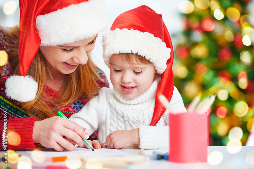 happy family mother and child daughter  write aletter to Santa o