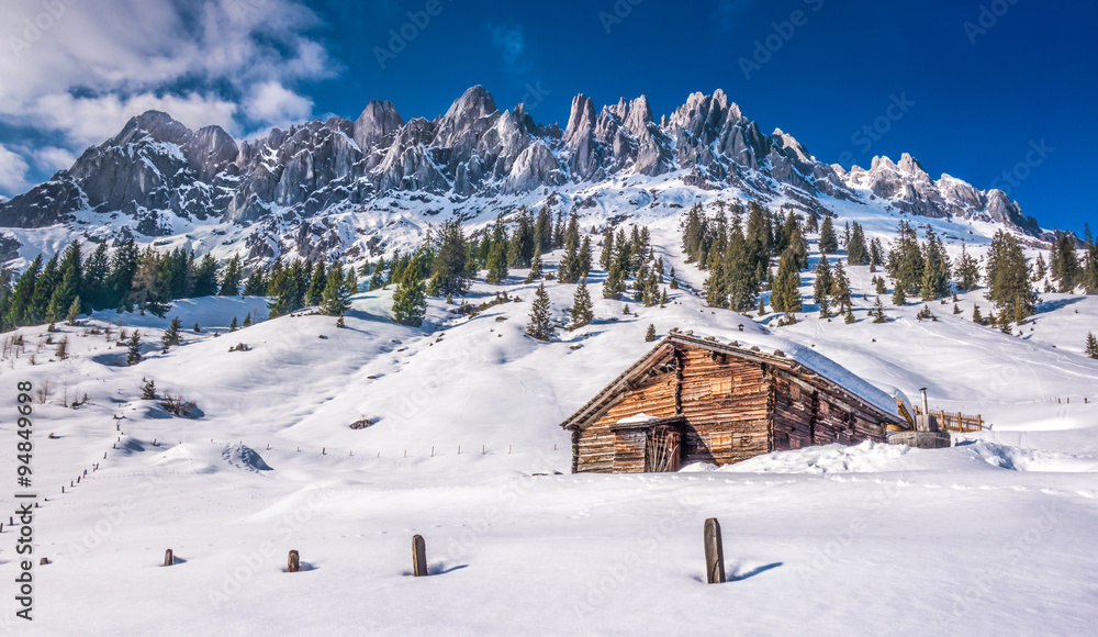 Idyllic winter wonderland scenery with traditional mountain chalet in the Alps