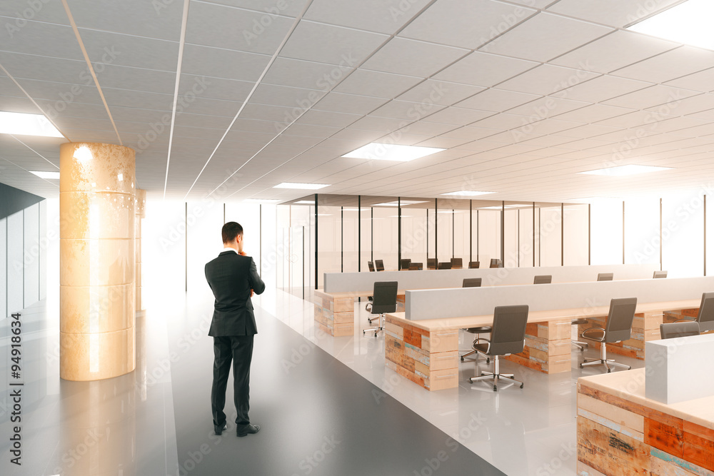 Businessman in modern open space office with furniture