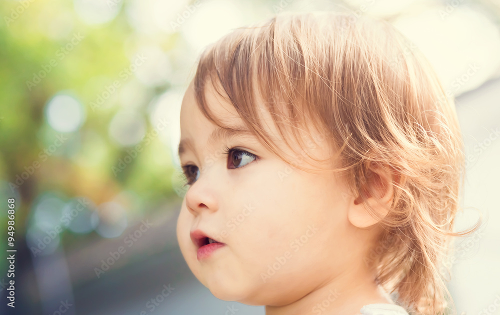 Close up portrait of a happy toddler girl outside 