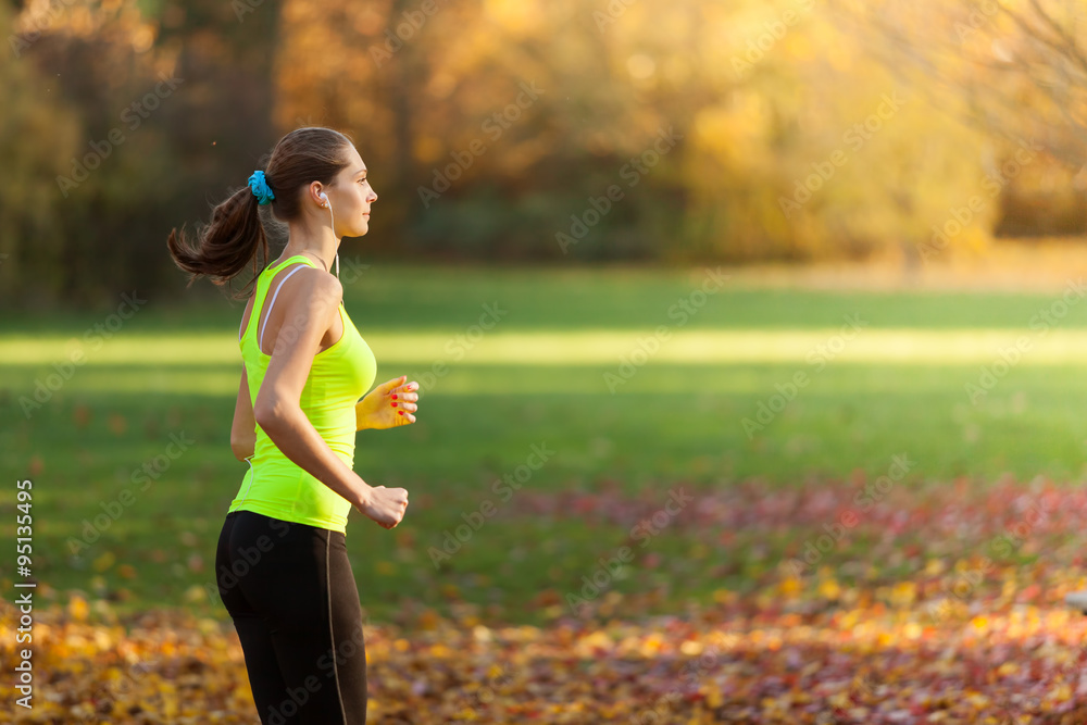 Female fitness model training outside and running.