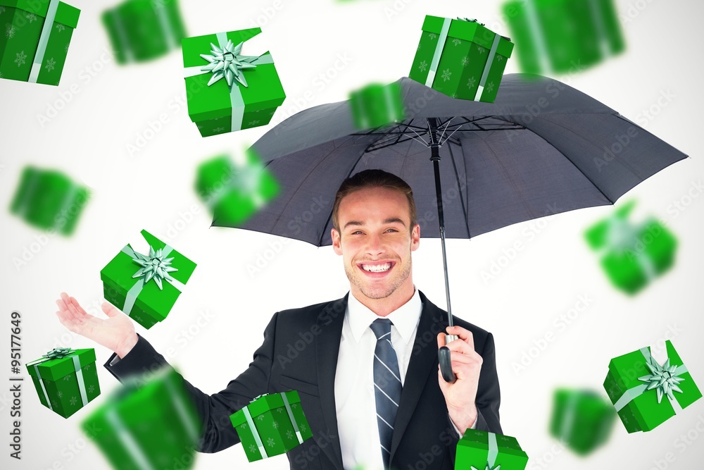 Composite image of businessman sheltering under black umbrella