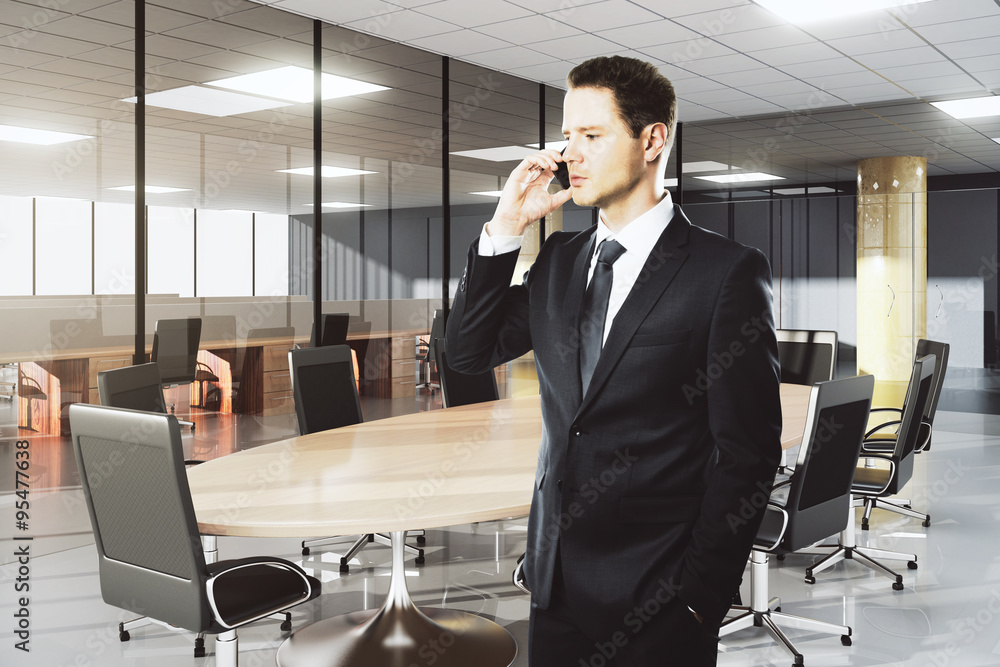 Businessman talking on the phone in modern conference room