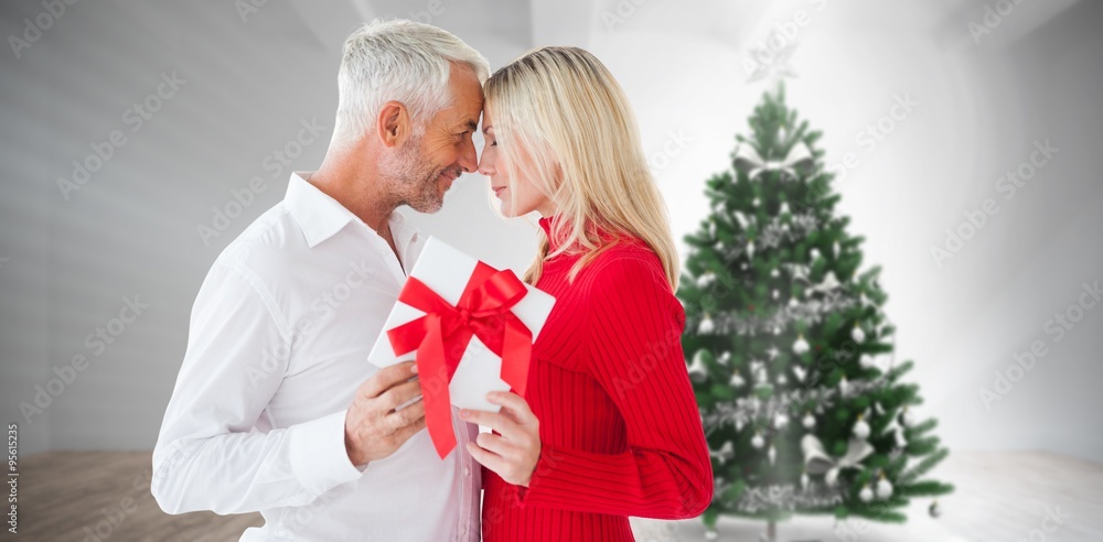 Composite image of loving couple with gift