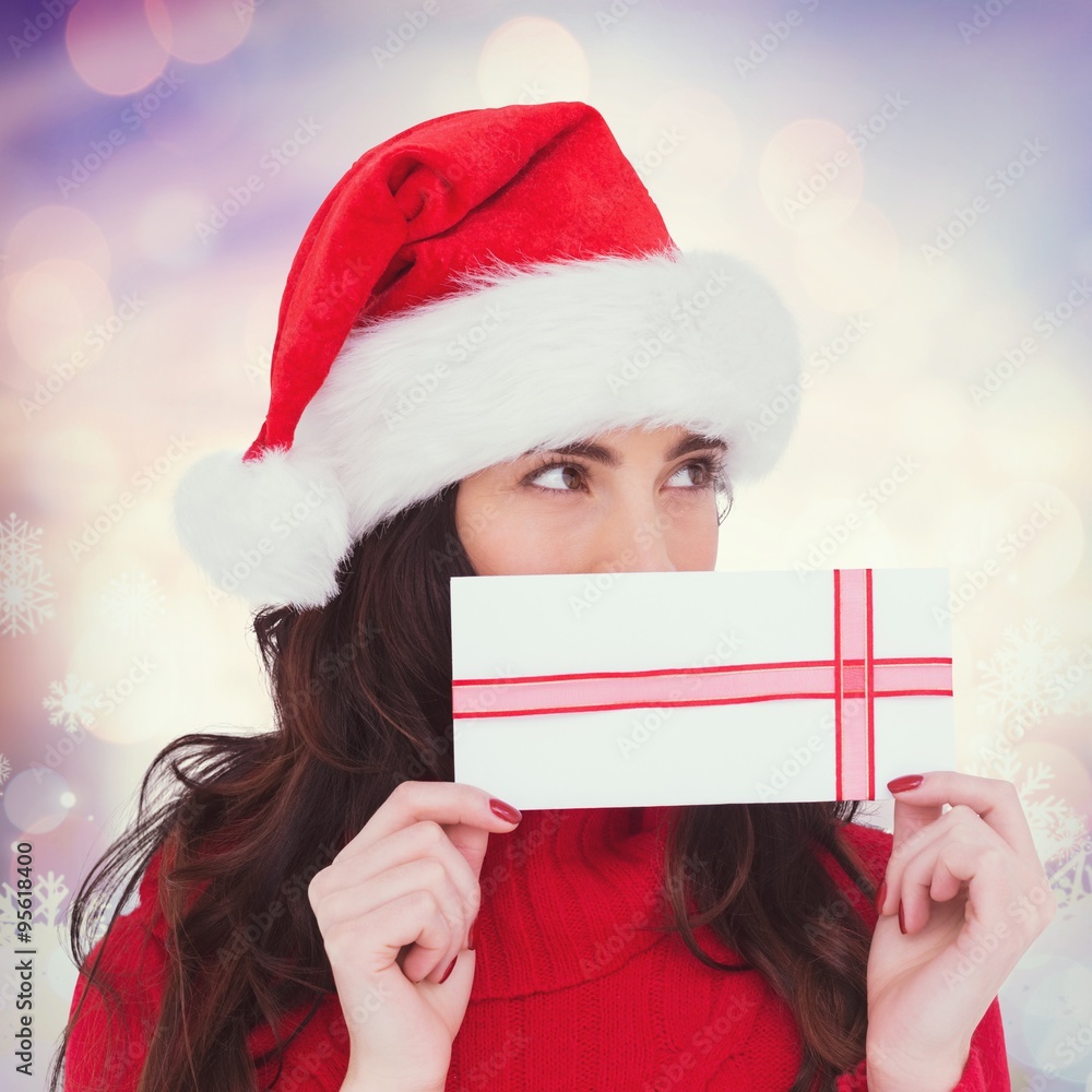 Composite image of festive brunette holding a gift