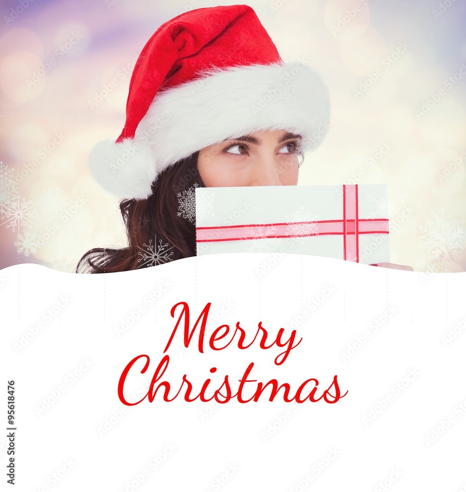 Composite image of festive brunette holding a gift