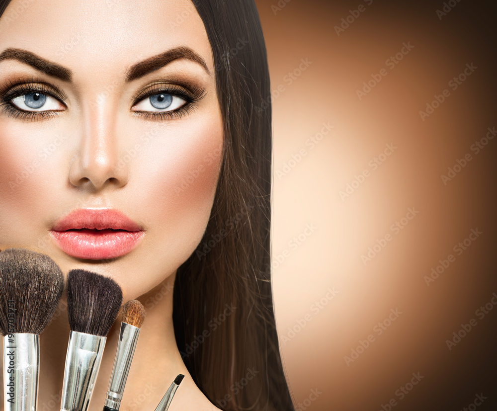 Beauty brunette girl with makeup brushes