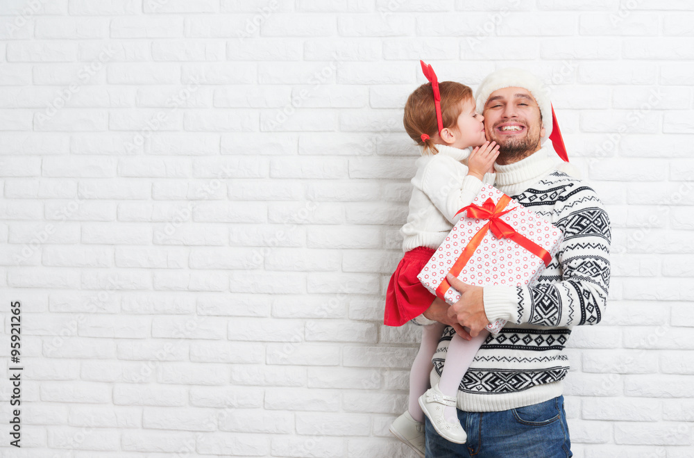 Happy family father and child with gift in Christmas kiss