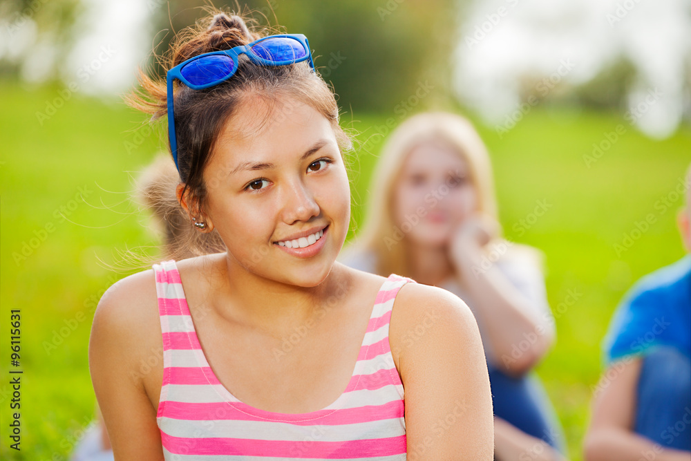 Portrait of Asian girl sitting on grass in park