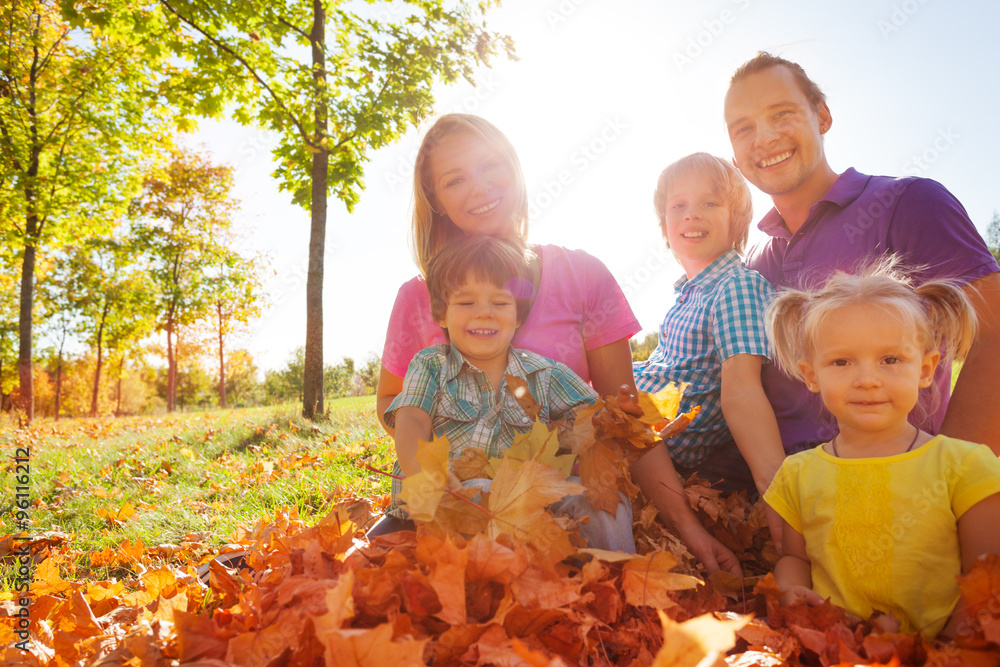 Family sitting together on leaves in the park