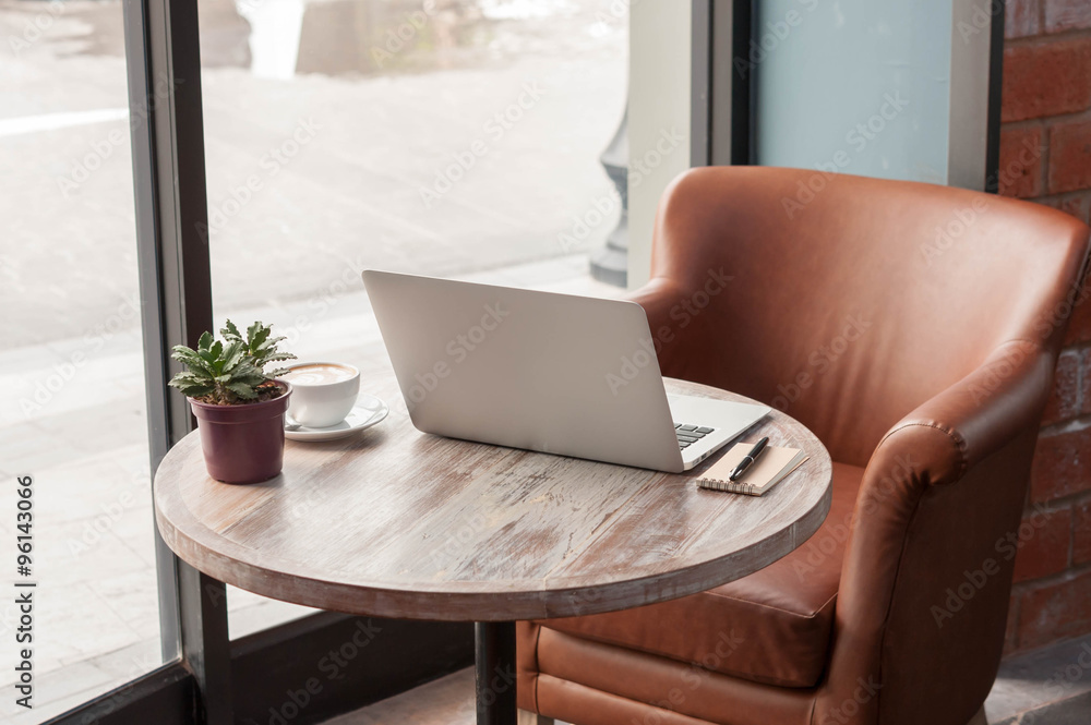 Laptop with tablet, pen and a cup of fresh coffee latte art on w