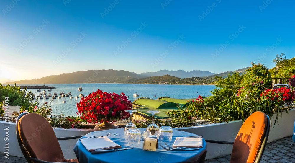 Romantic dinner place with idyllic panoramic view of mediterranean coastal landscape at sunset in go