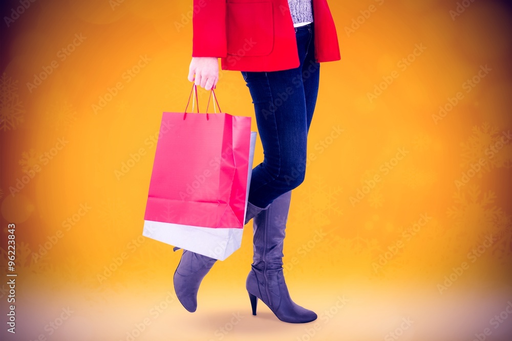 Happy blonde in winter clothes holding shopping bags