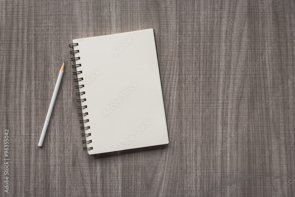 white pencil and blank notebook