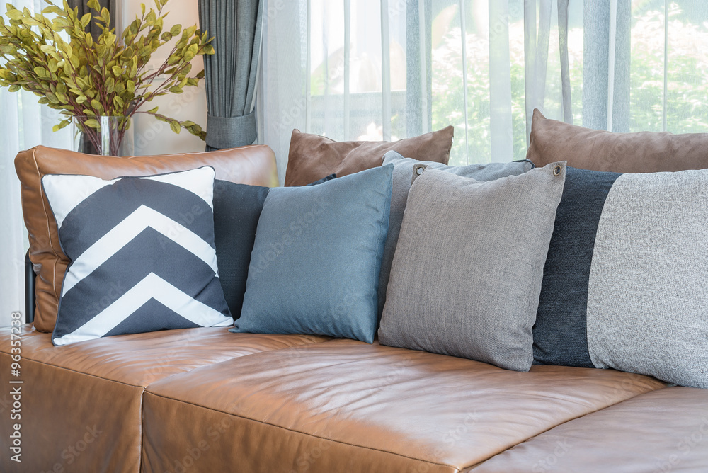 pillows on brown leather sofa