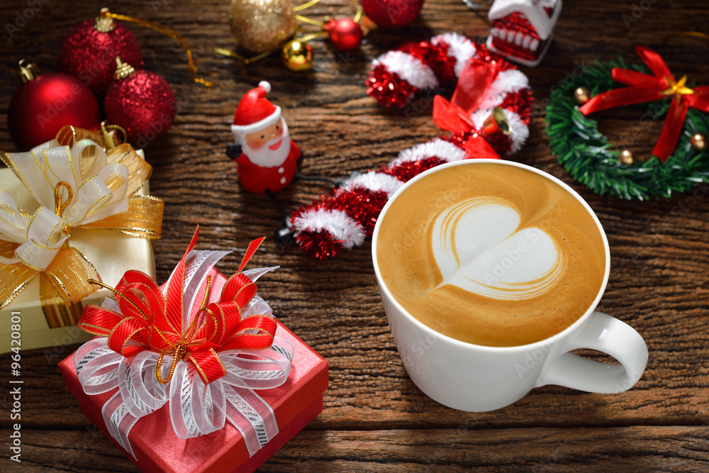 Latte Art, cup of cafe latte surrounded by Christmas decorations on wooden background