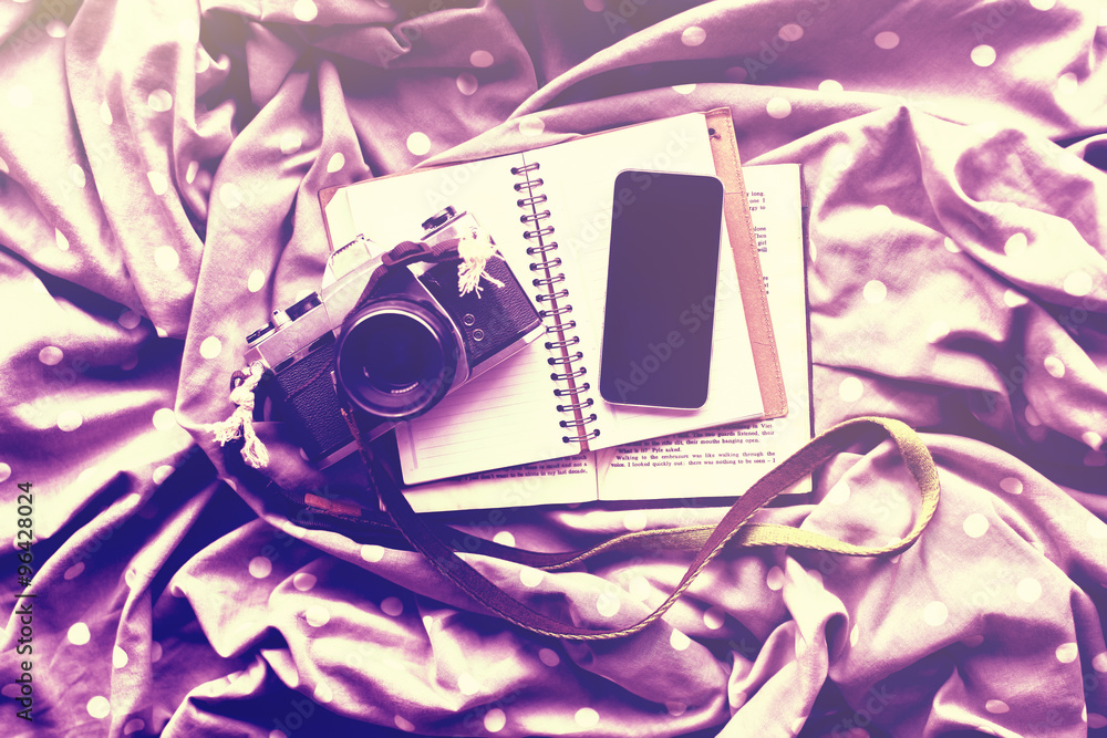 Blank black smartphone with diary, vintage camera and book