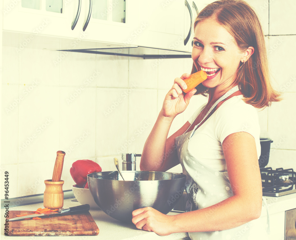 young happy woman cook vegetable salad on kitchen