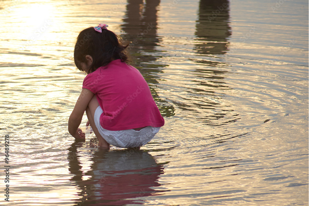 Cute little girl play in the water at the beach