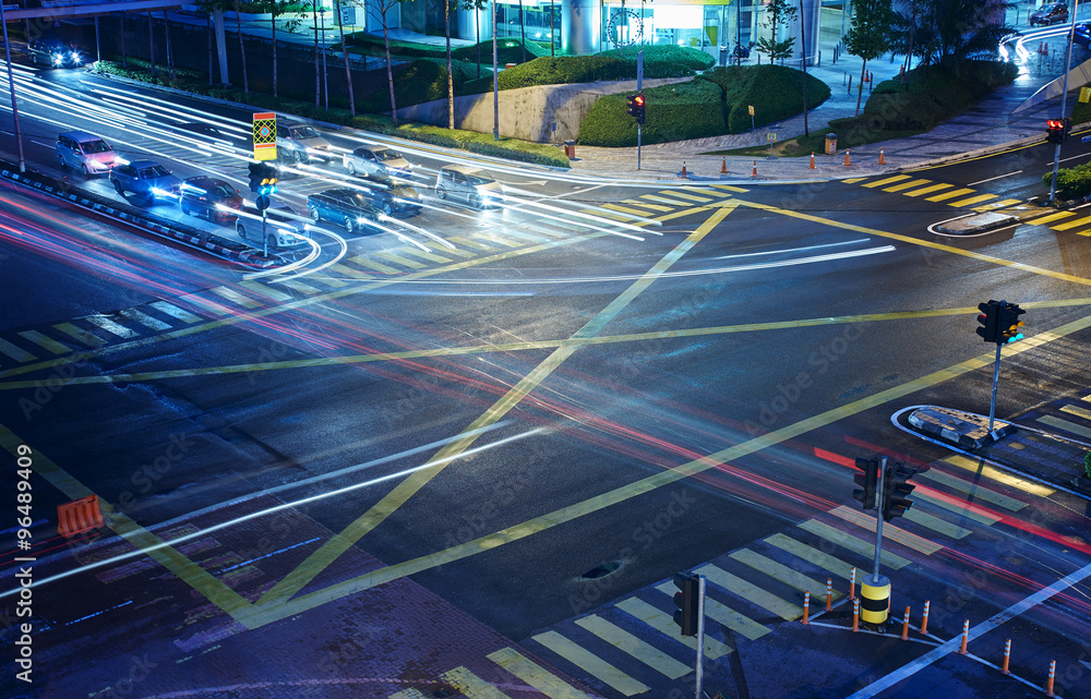 A high angle view of  treet intersection, with yellow cross walk markings, traffic signal lights, an