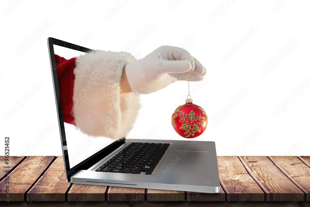 Composite image of santas hand is holding a christmas bulb 