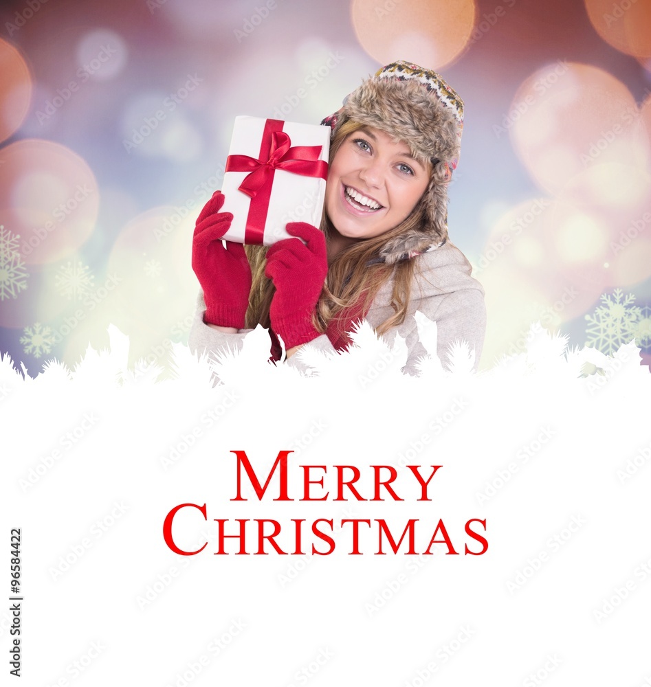 Composite image of happy blonde in winter clothes holding gift