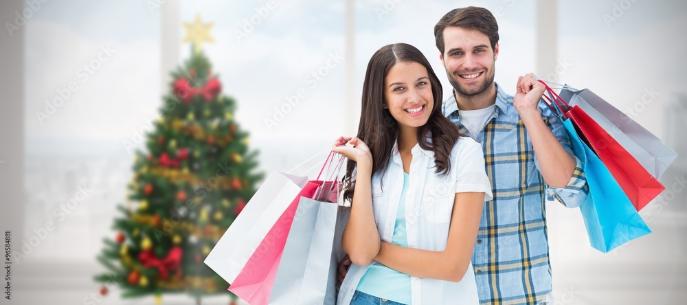 Composite image of happy couple with shopping bags