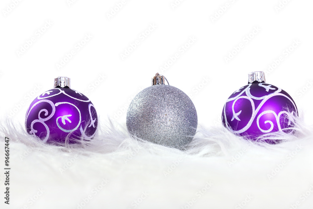 Purple and silver christmas baubles over white background