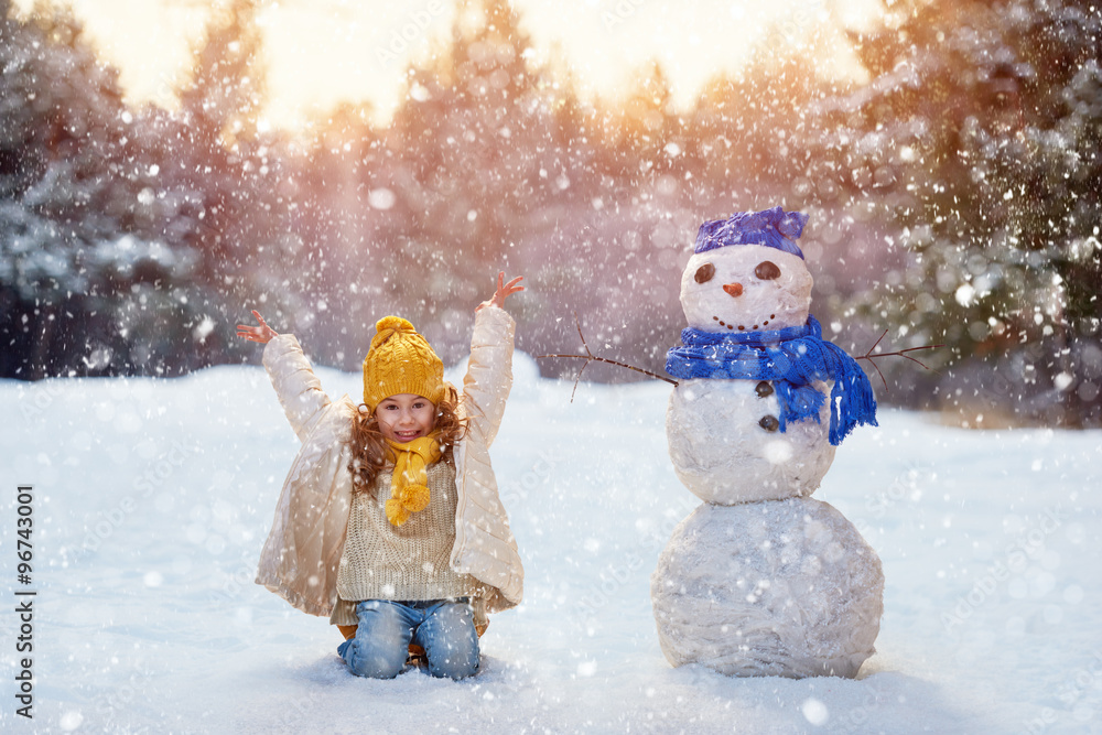 girl playing with a snowman