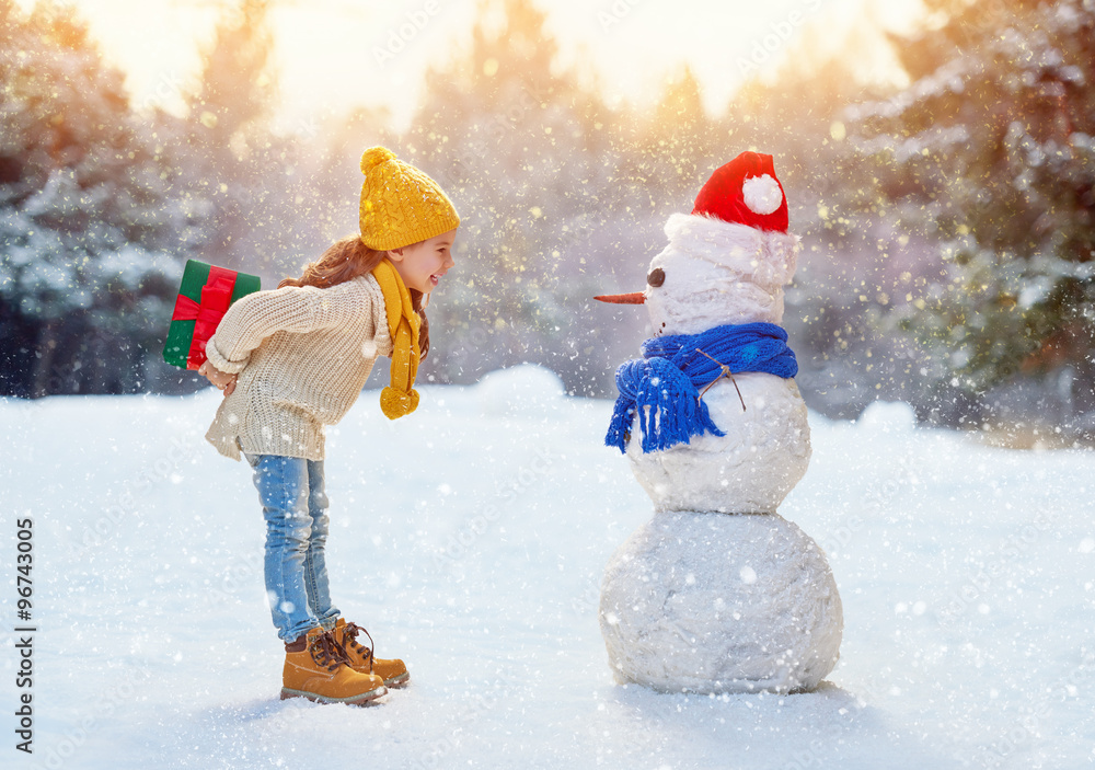 girl playing with a snowman