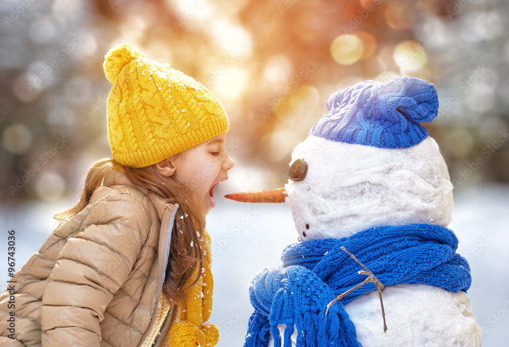 girl playing with a snowman