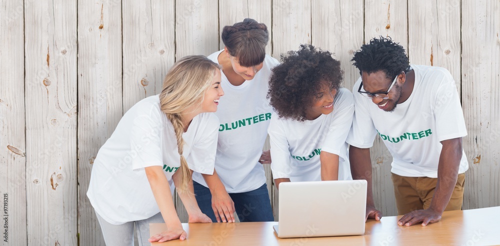 Smiling volunteers working together on a laptop