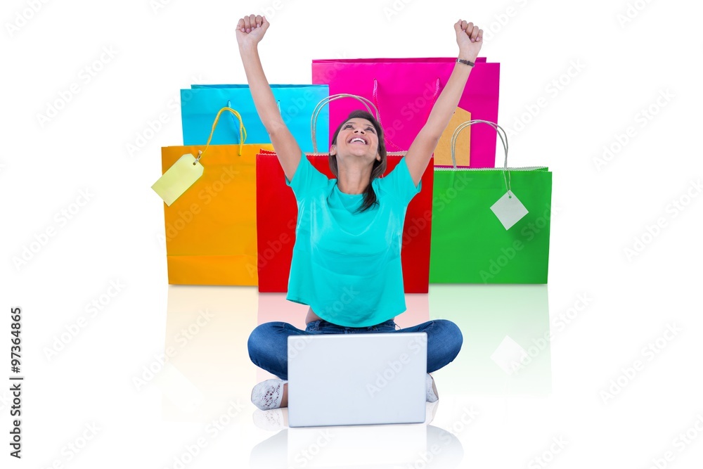 Woman with arms raised against shopping bags