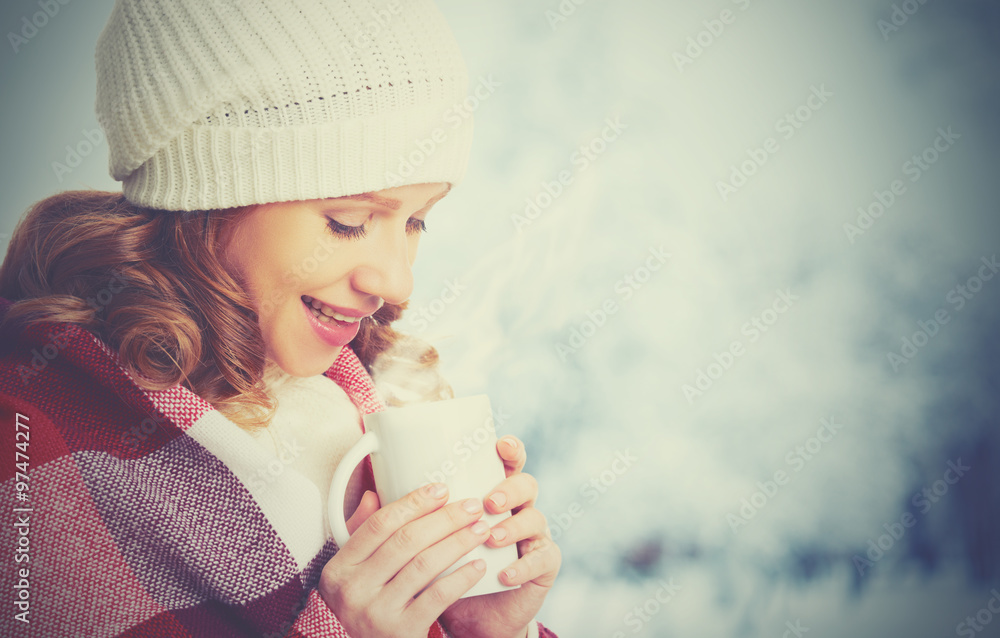 happy woman with  cup of hot drink on cold winter outdoors