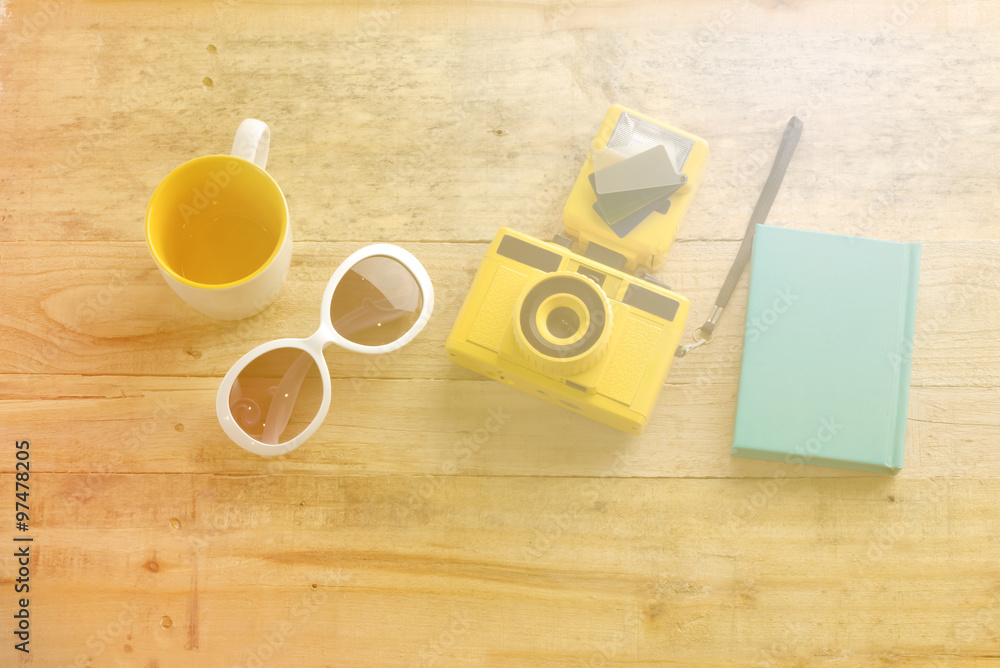 close up of camera notebooks sun glasses on wooden table