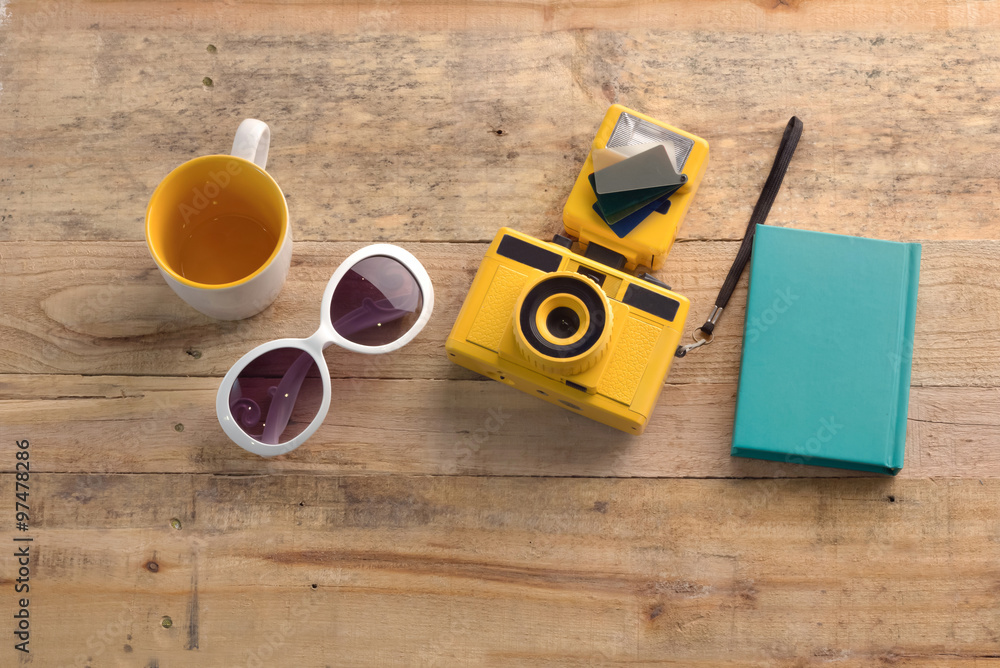 close up of camera notebooks sun glasses on wooden table