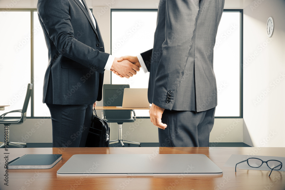 Two businessman shaking hands in a modern office