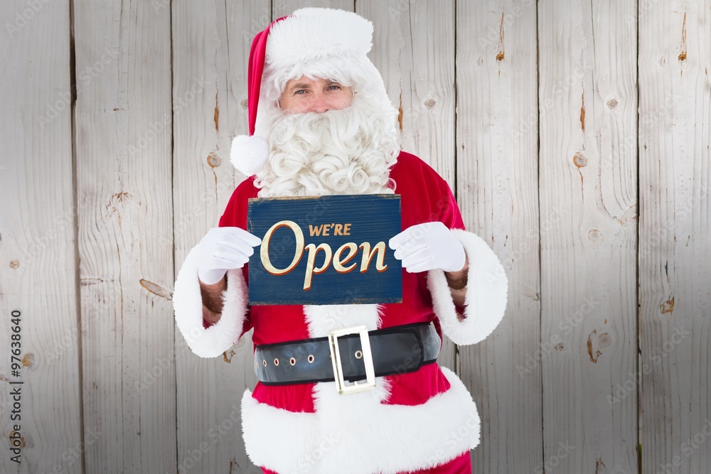 Composite image of smiling santa claus holding page