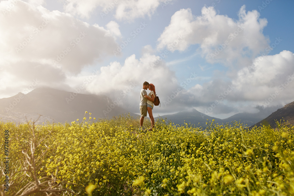 Romantic young couple embracing on hill top