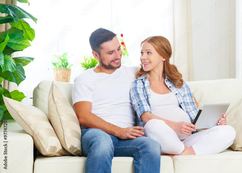 Happy parents waiting malyshayu pregnant mom and dad with tablet