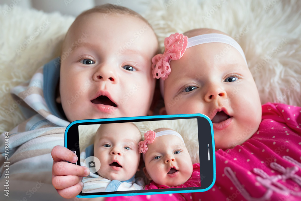 Twins taking selfie with a cell phone camera