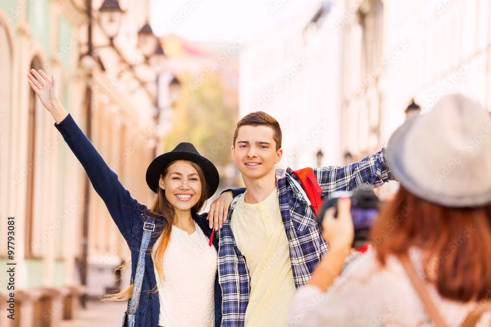 Happy couple stand close and girl shooting them