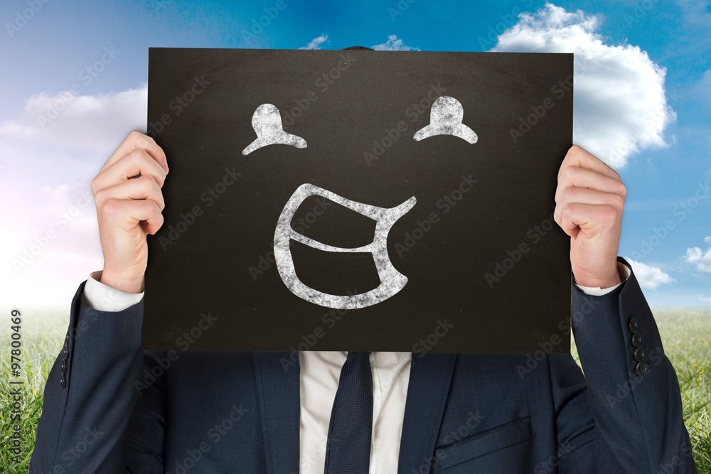 Composite image of businessman holding board