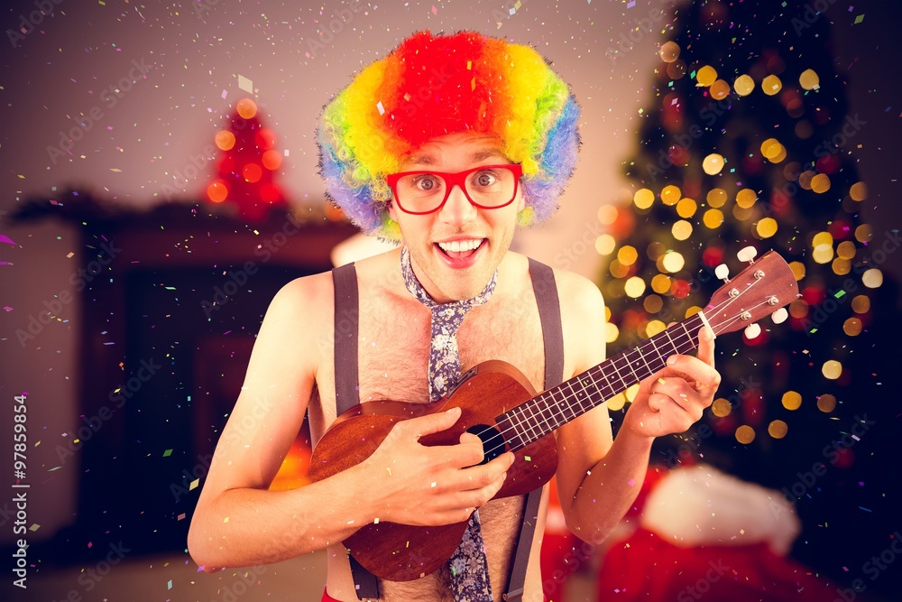 Geeky hipster in afro rainbow wig playing guitar