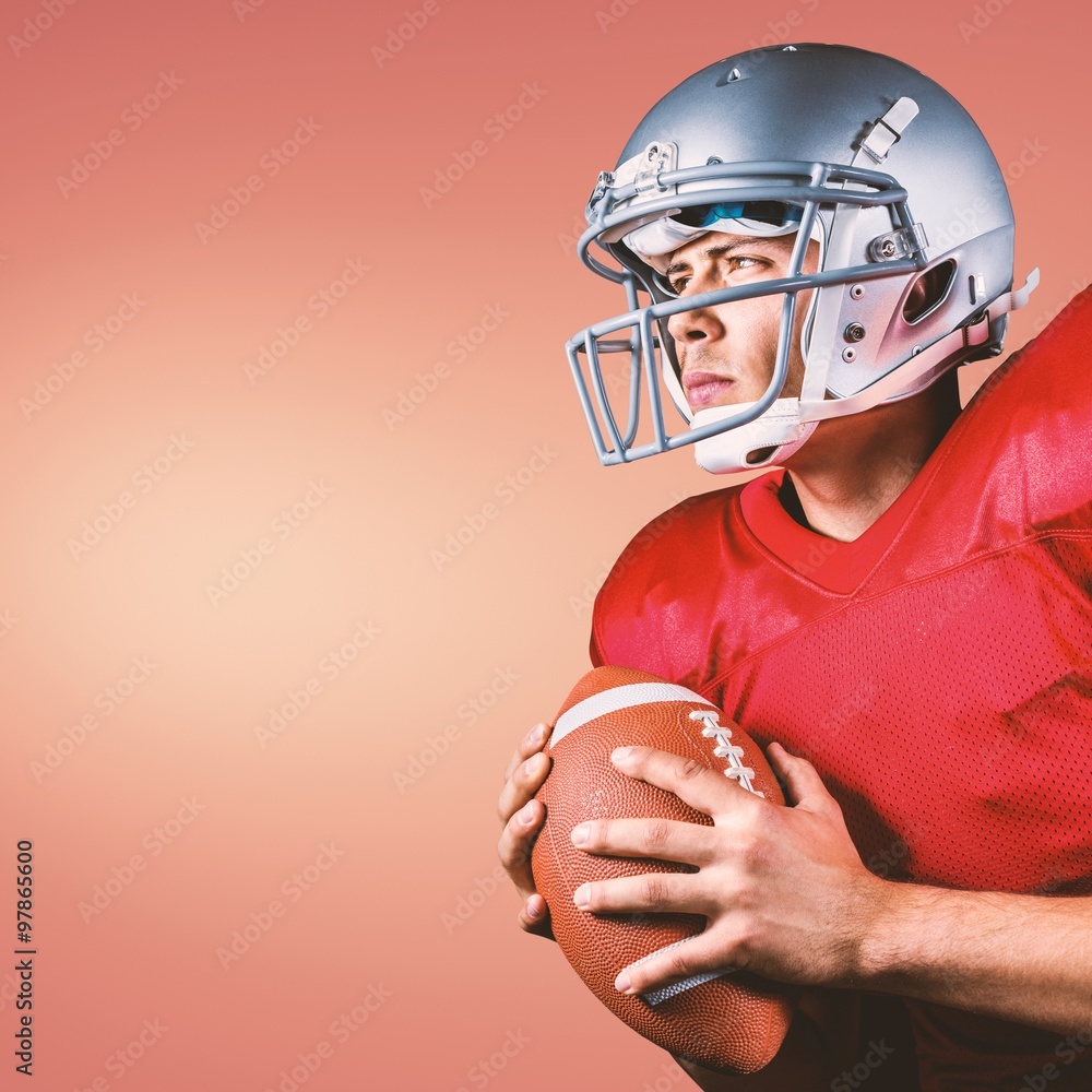 American football player looking away holding ball